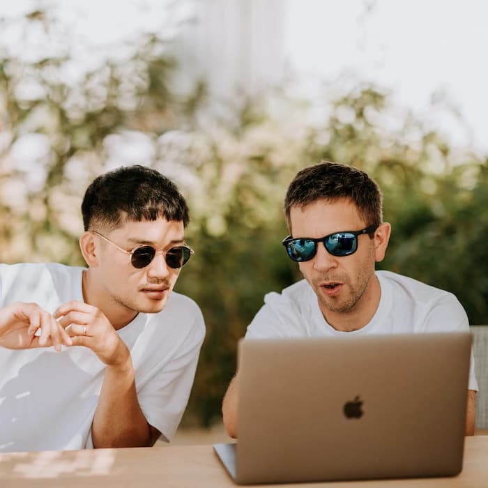 Un homme explique quelque chose à un autre sur son ordinateur