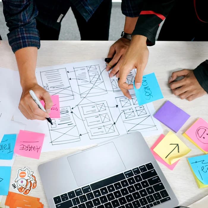 3 personnes font un brainstorming en écrivant sur des post-it